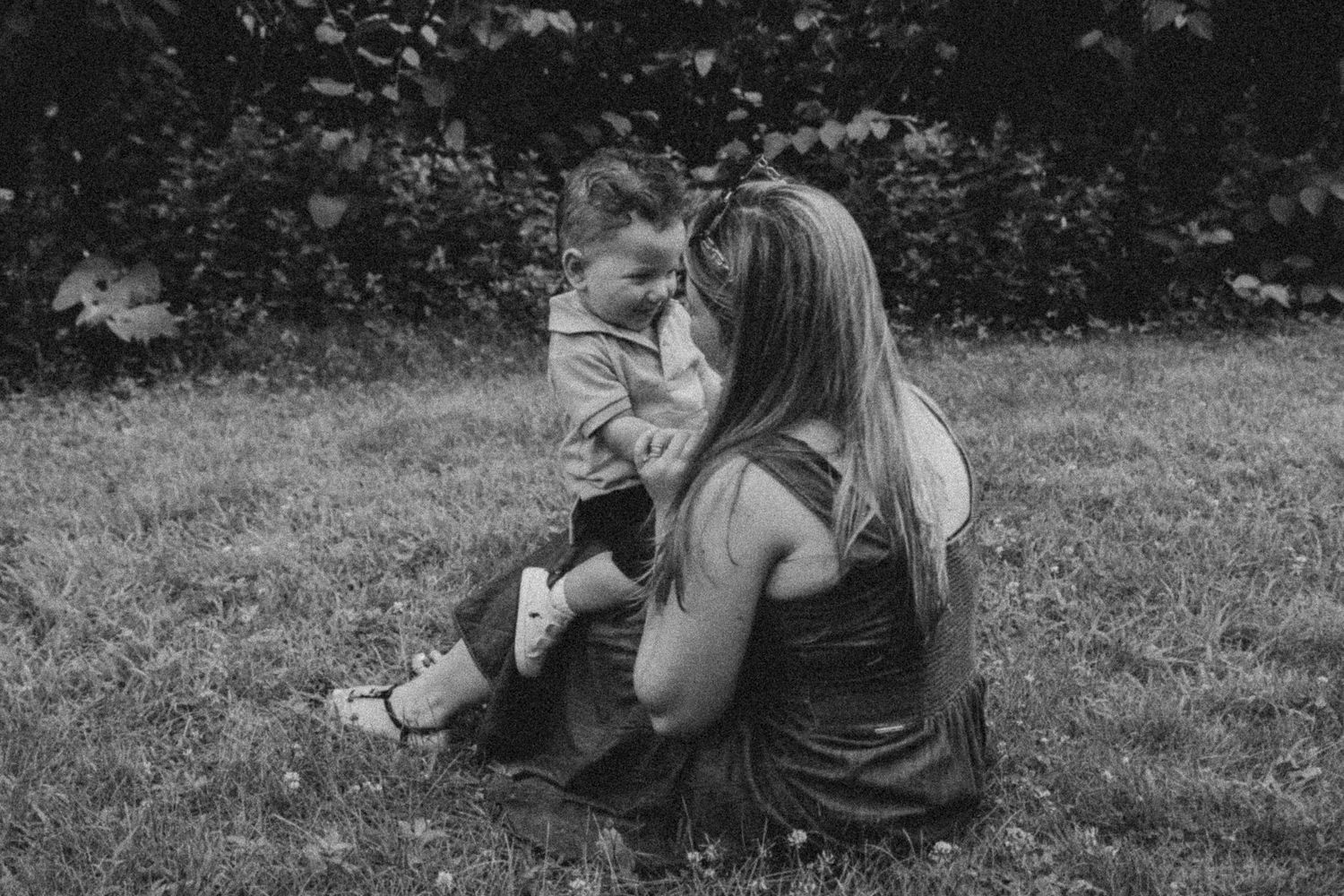 A romantic black and white photo series showing tender moments between a couple embracing outdoors in nature.