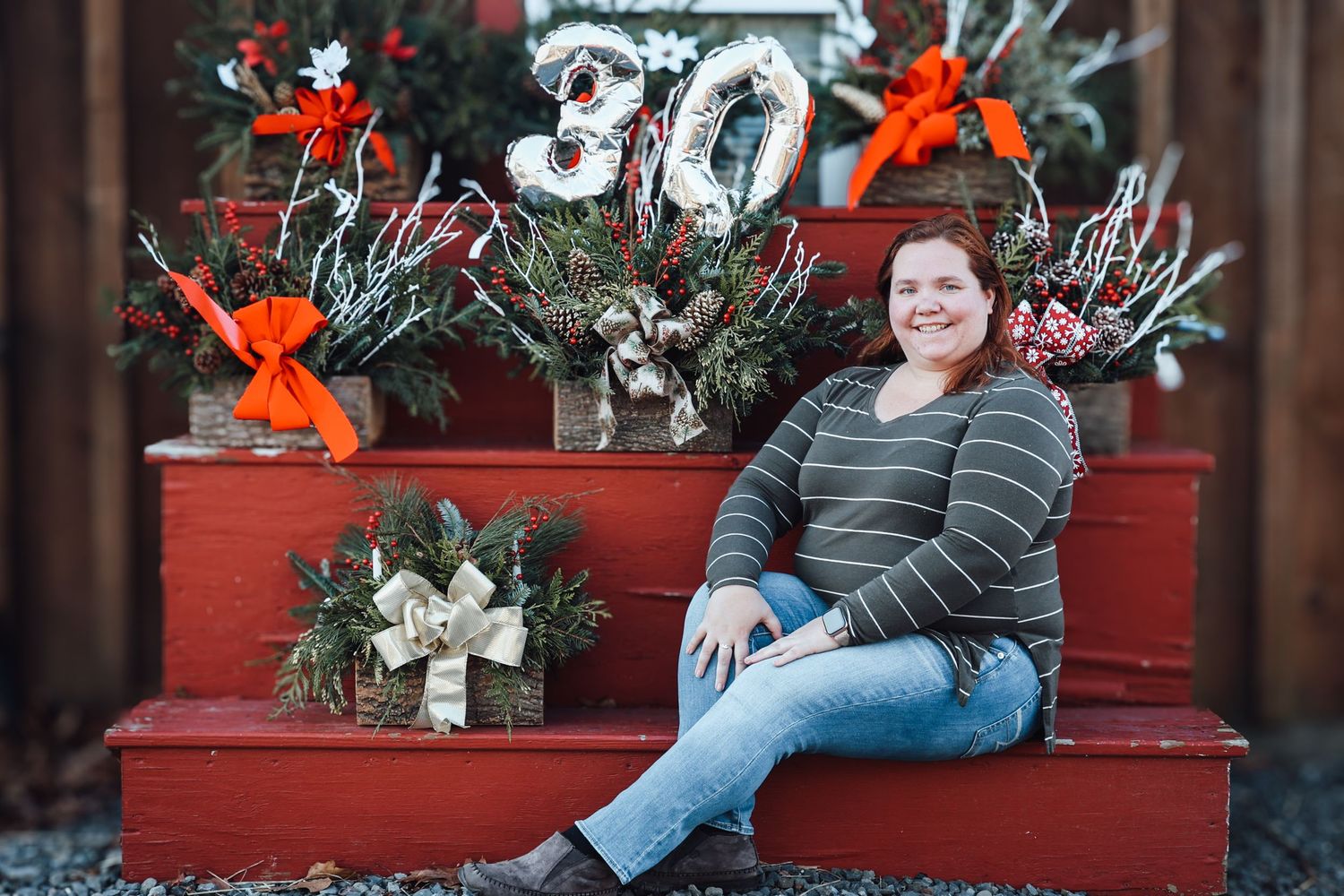 Festive holiday scene with red stairs decorated with winter greenery, white flowers, and a large number 30 display.