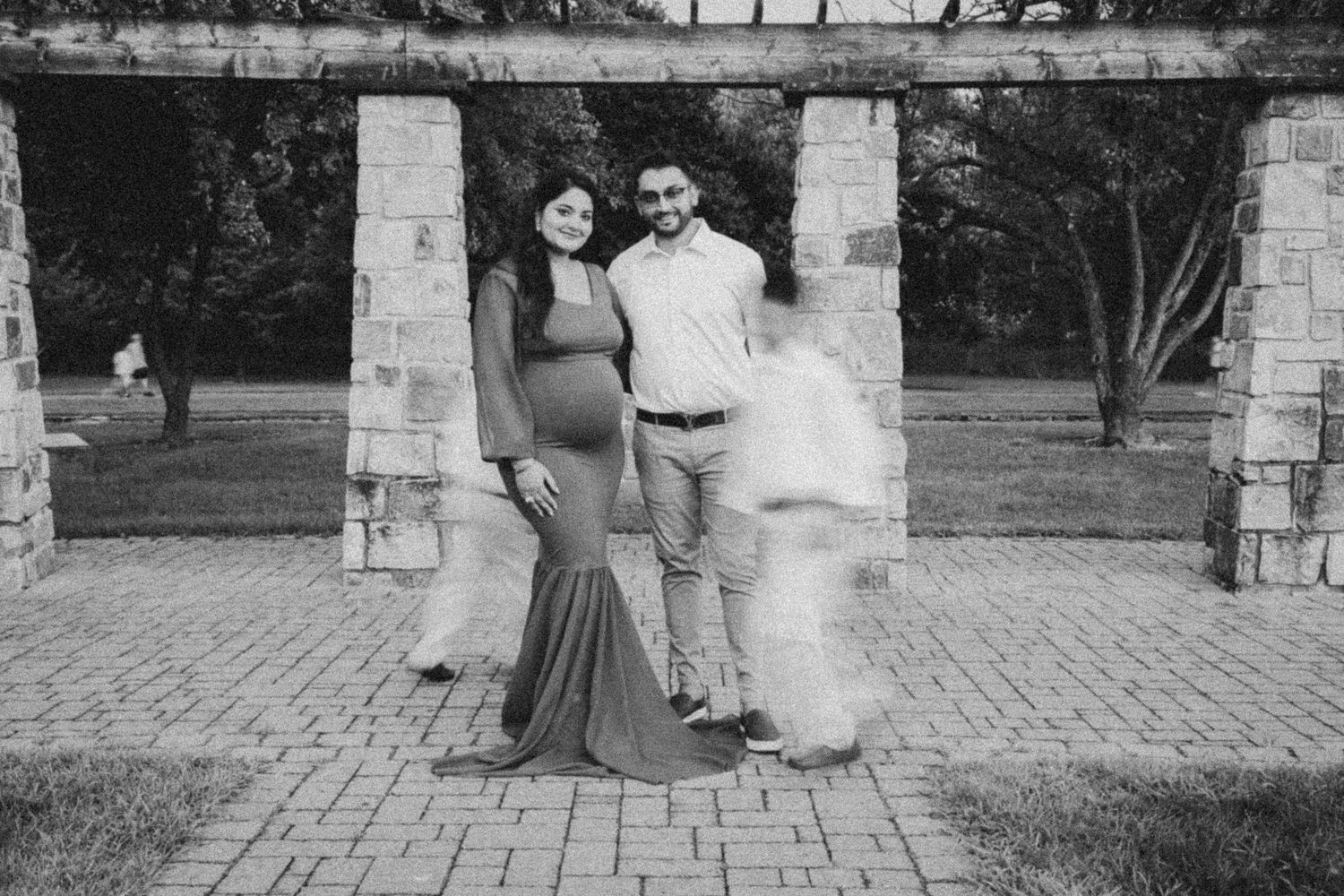 A black and white photo collage showing multiple wedding moments at a stone archway venue.
