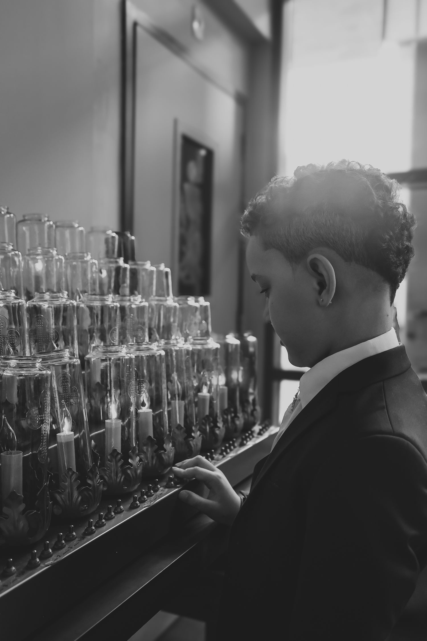 A black and white image sequence shows someone examining rows of glass bottles on shelves in a laboratory setting.