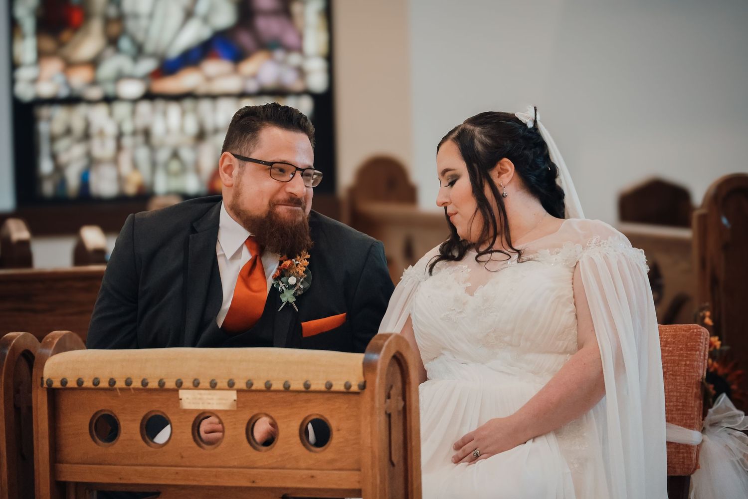 A wedding couple shares an intimate moment during their ceremony in a rustic indoor venue.