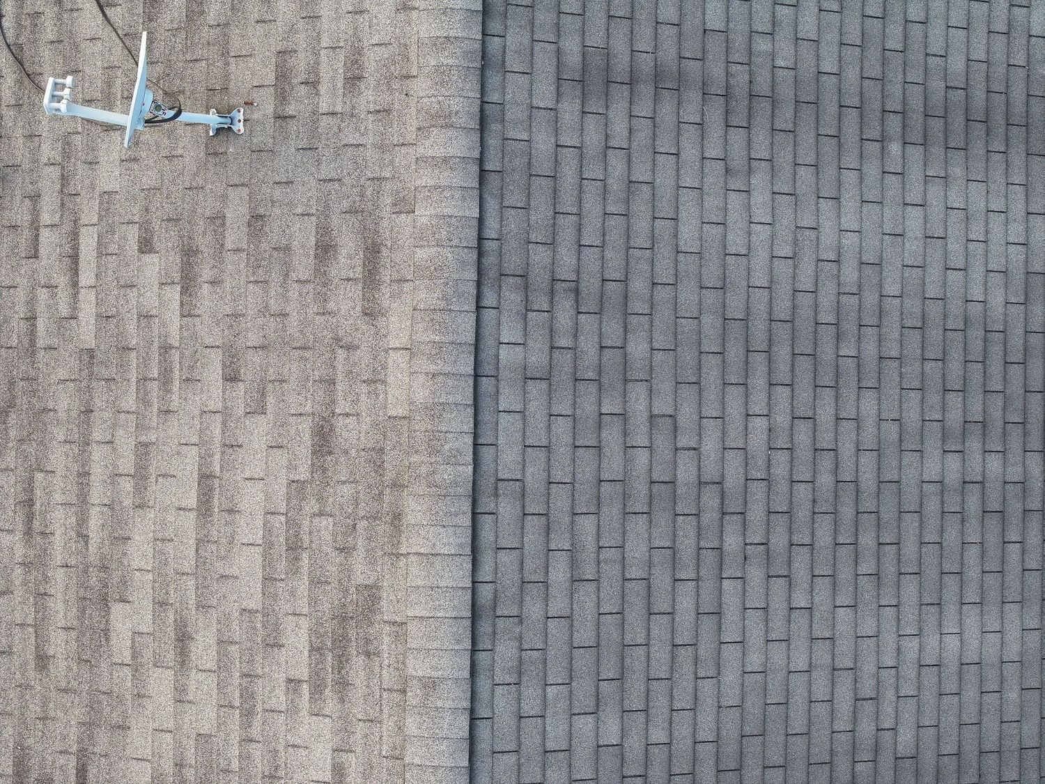 A close-up view of gray asphalt shingles on a residential roof showing overlapping pattern and texture.
