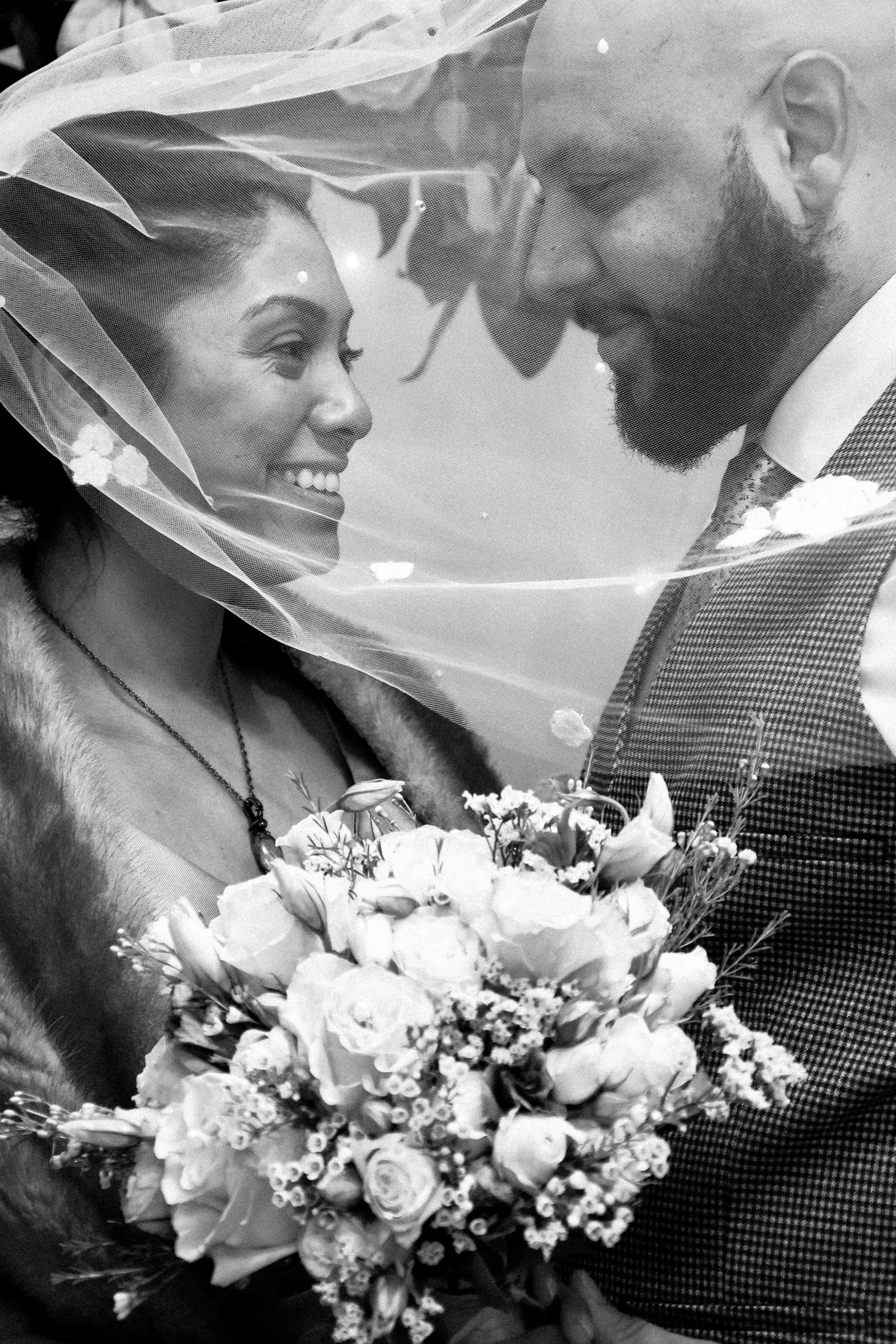 A romantic black and white wedding photo series showing close-up moments with a bridal bouquet of white flowers.