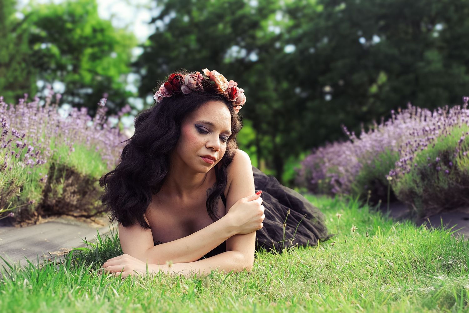 A person lying in a field of lavender flowers on a sunny summer day.