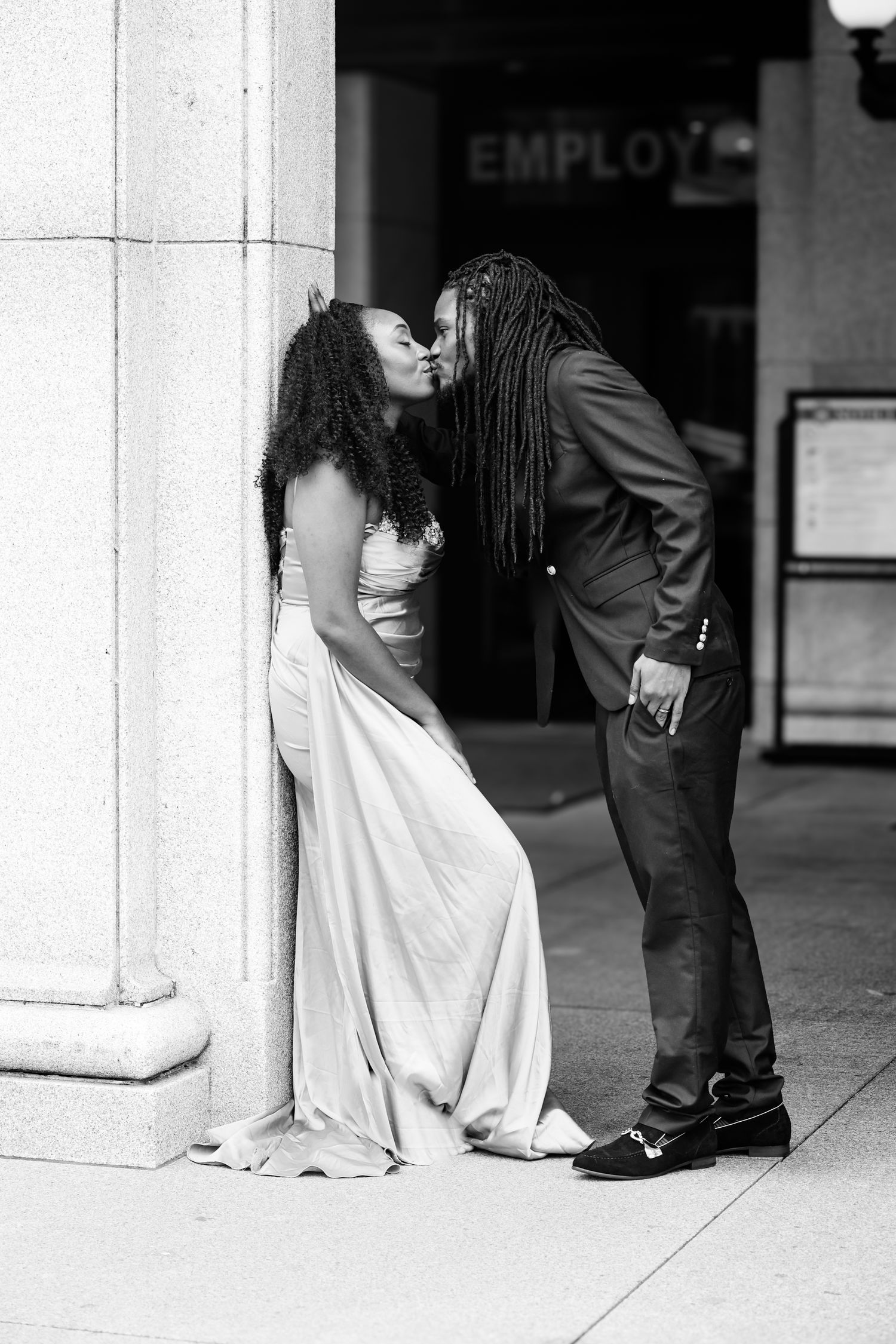 A sequence of black and white photos showing a romantic couple interacting near a building column.