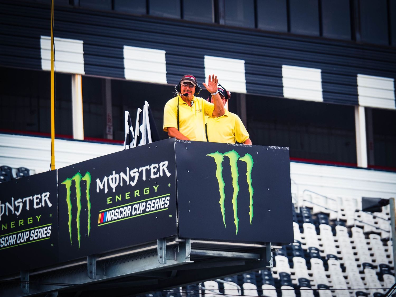 A row of white stadium seats with Monster Energy branding and signage visible along the top of the seating area.