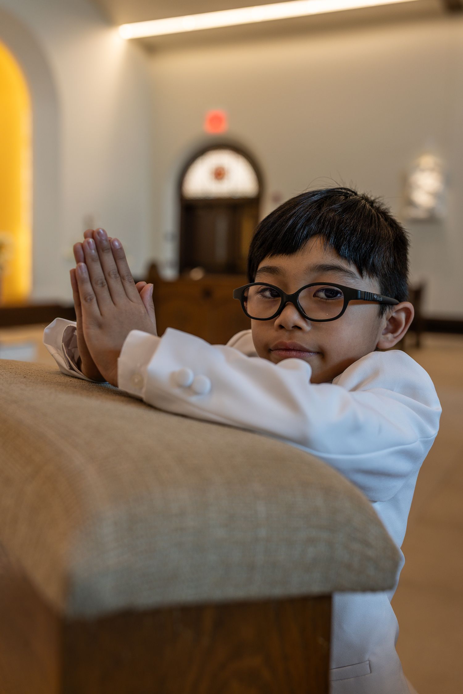 A child in glasses and white sweater leans over a brown couch cushion in a series of sequential photos.