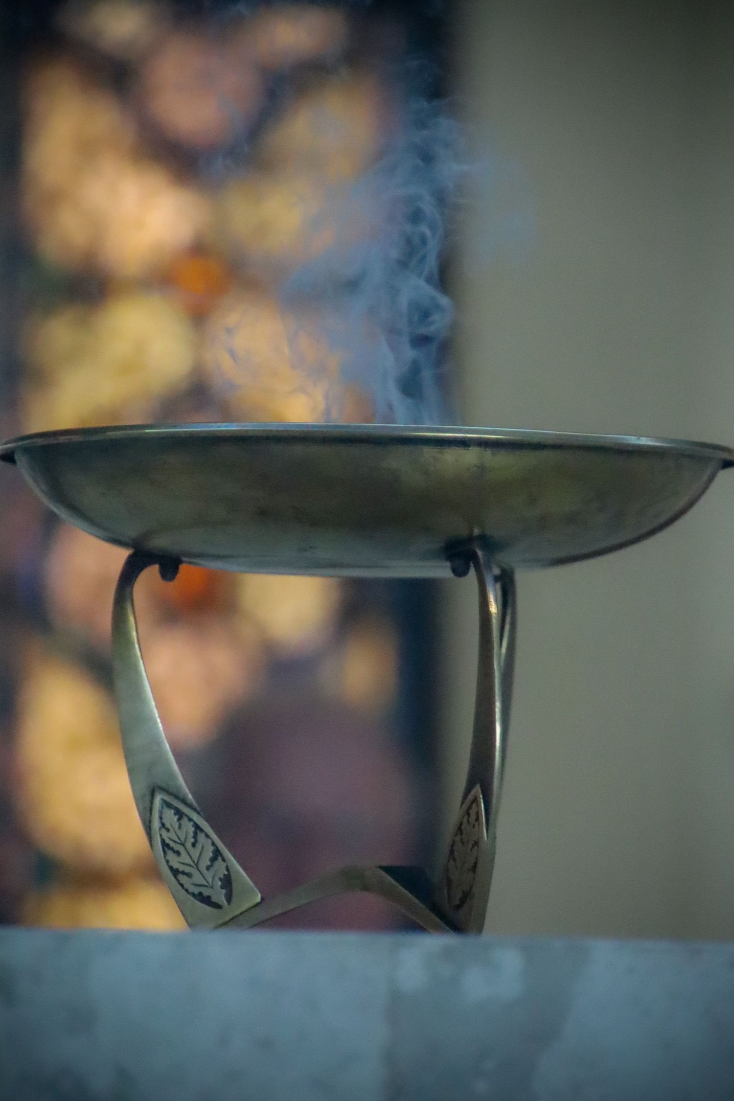 Close-up series of a metal leaf-shaped decorative bracket with a rustic patina against a blurred background.