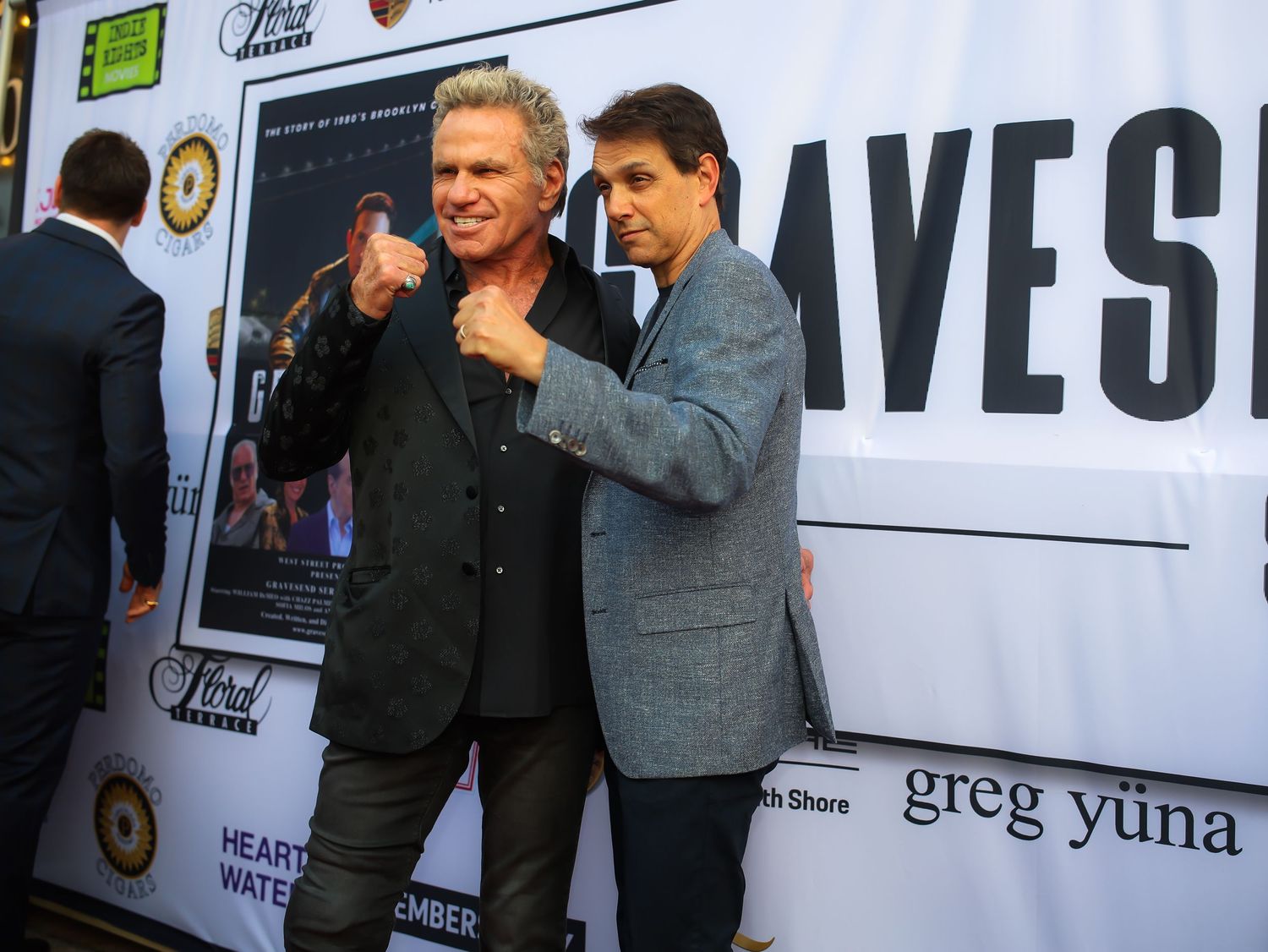 Two people in formal attire stand together at what appears to be a media or entertainment industry event.