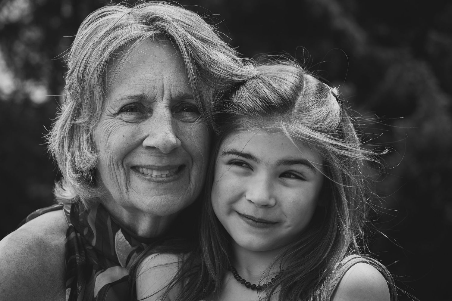 A series of black and white portraits showing tender moments between two people smiling and embracing.