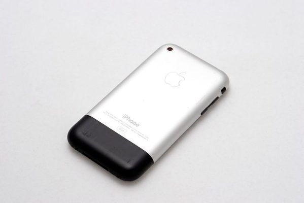 Original first generation iPhone with silver aluminum back and black plastic antenna section shown from behind.