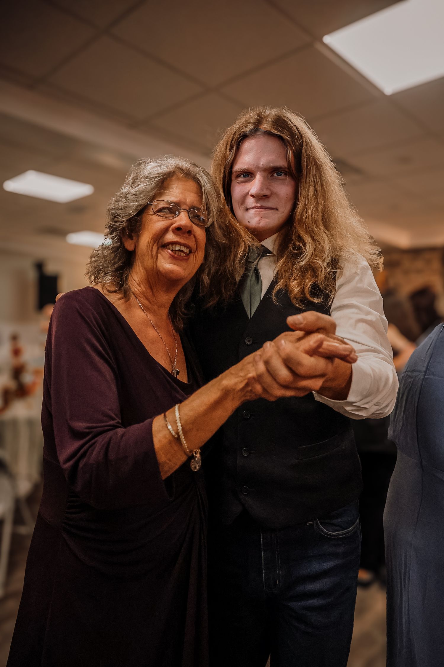 Two people dancing together in an indoor space with warm lighting and a casual atmosphere.