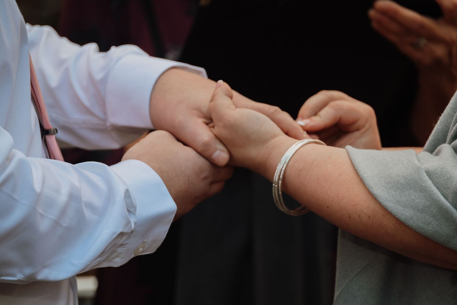 A close-up sequence of hands exchanging a small object or performing a transaction in a professional setting.