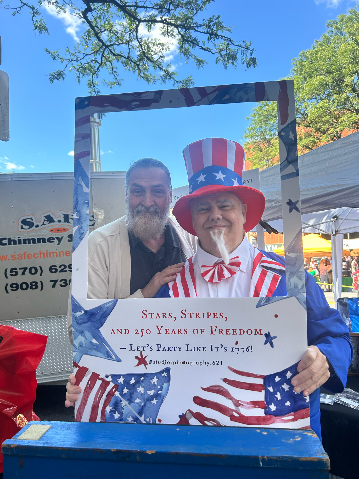 Patriotic outdoor display with American flags and red, white and blue banners at a summer celebration event.