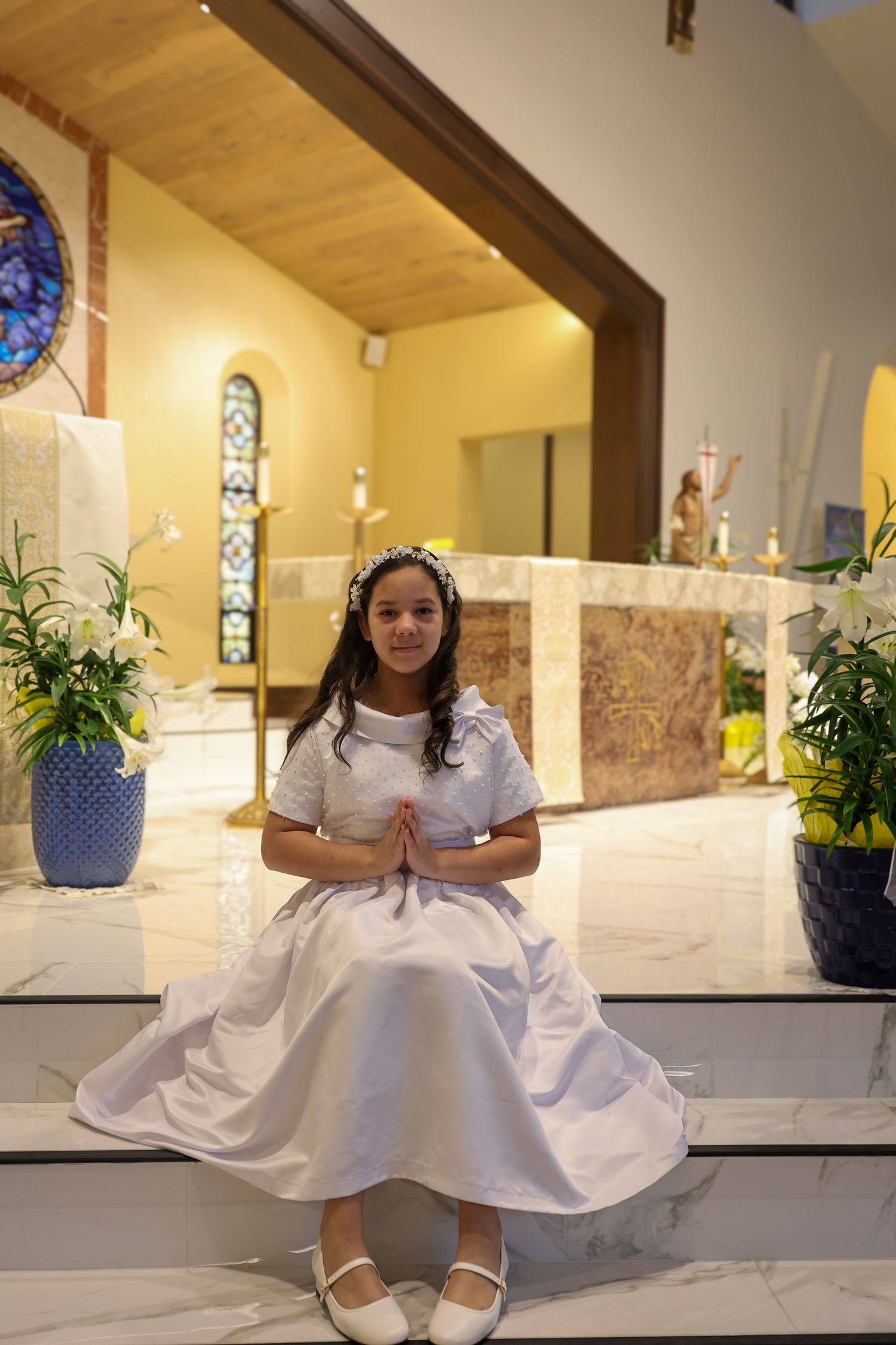 A figure in a white dress sits on church altar steps in a series of similar poses.