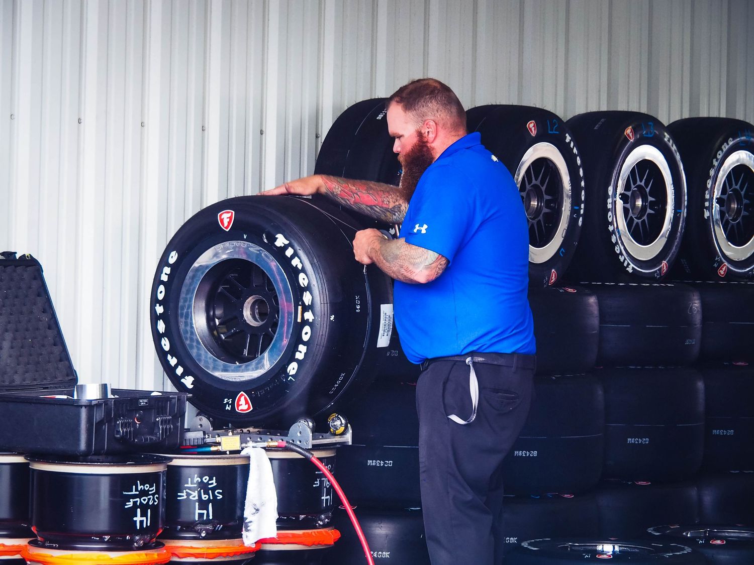 Tire technicians inspect and service large commercial truck tires in an automotive repair shop.