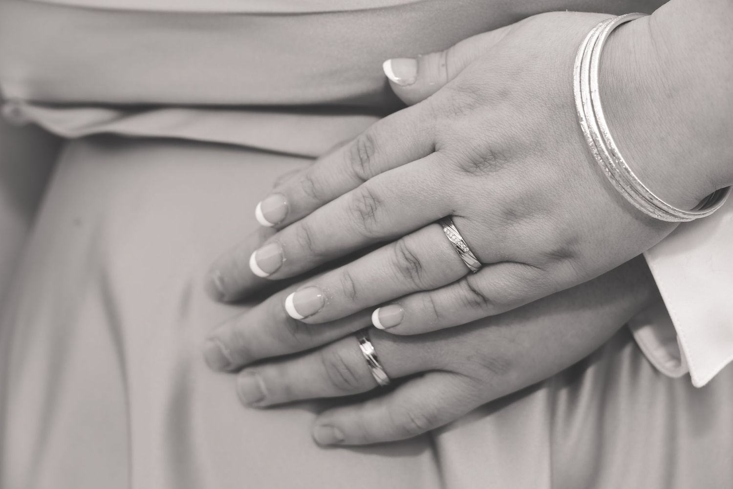 Close-up sequence of hands placing wedding rings on fingers during a marriage ceremony.