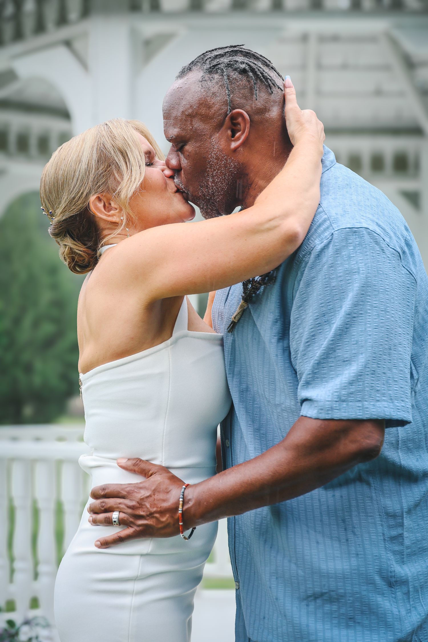 A romantic couple in blue and white outfits share tender kisses and embraces in a series of outdoor photos.