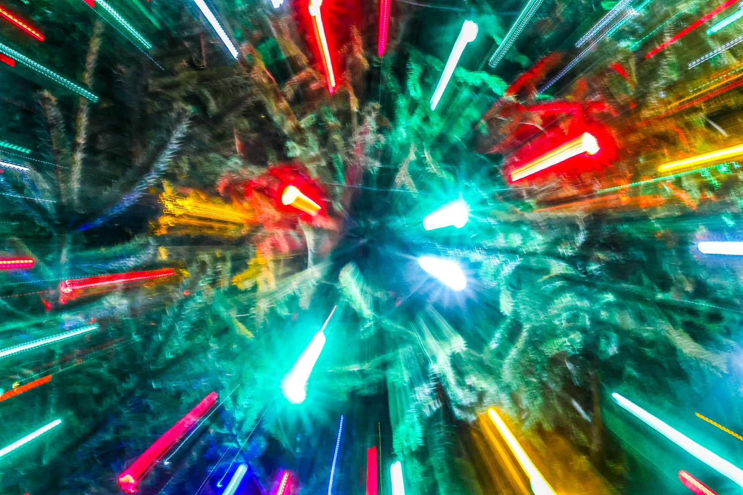 Abstract light trails create colorful streaks of red, green, and blue in a dynamic motion blur pattern.