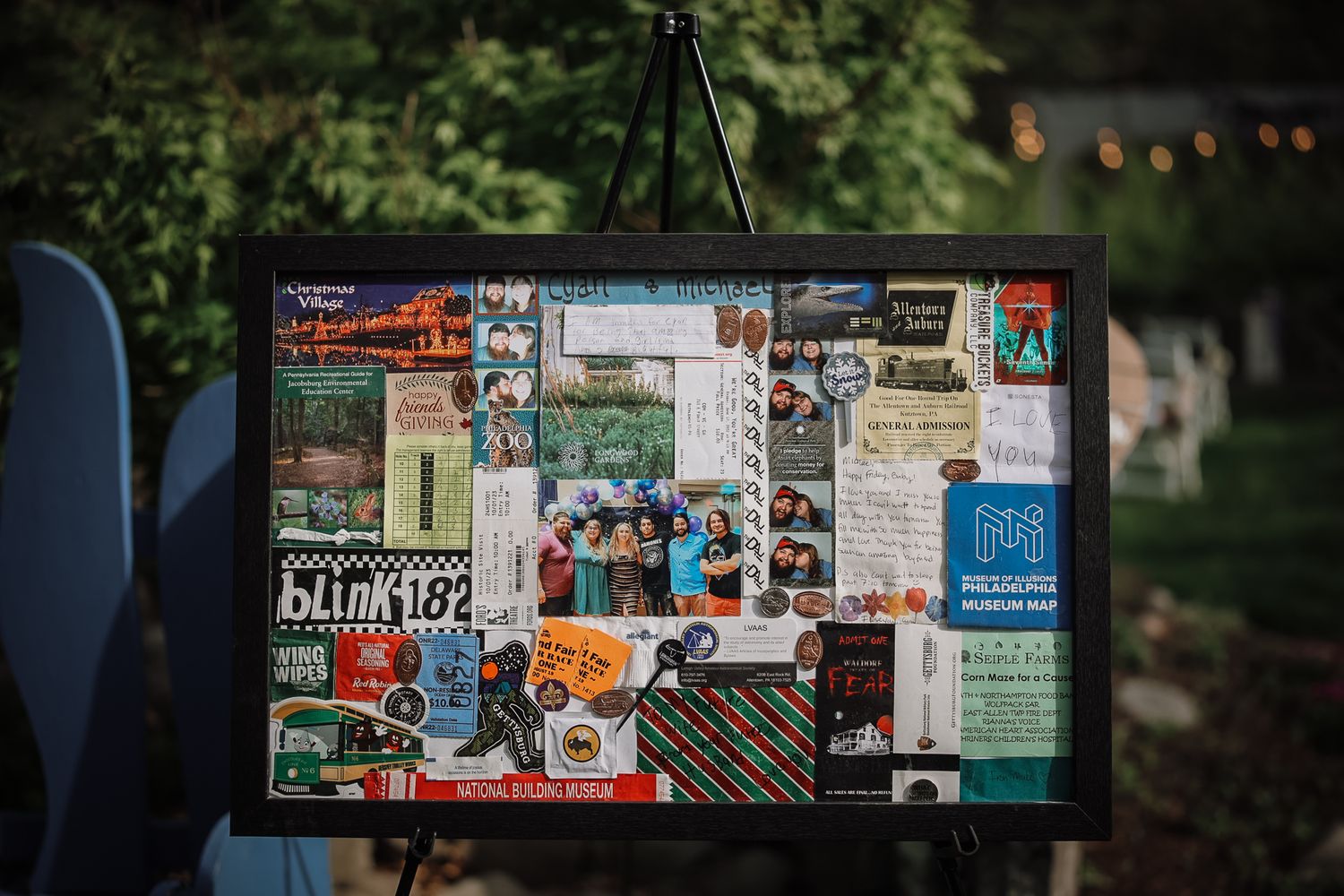 Colorful scrapbook collage display on easel outdoors featuring Blink-182 memorabilia and vintage ticket stubs.