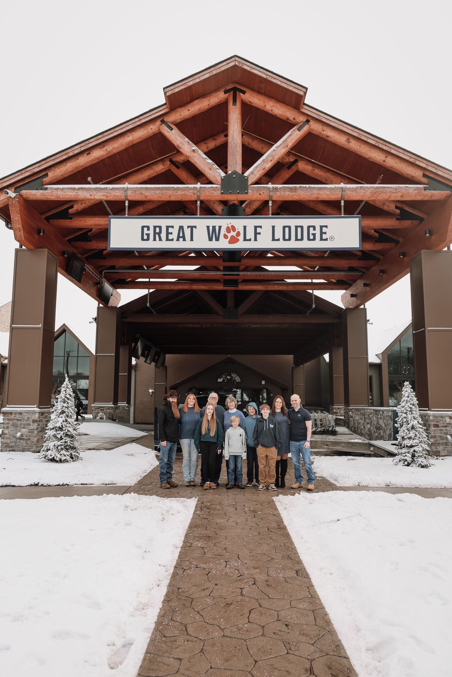 A series of five similar photos showing people standing outside the entrance of Great Wolf Lodge in snowy winter conditions.