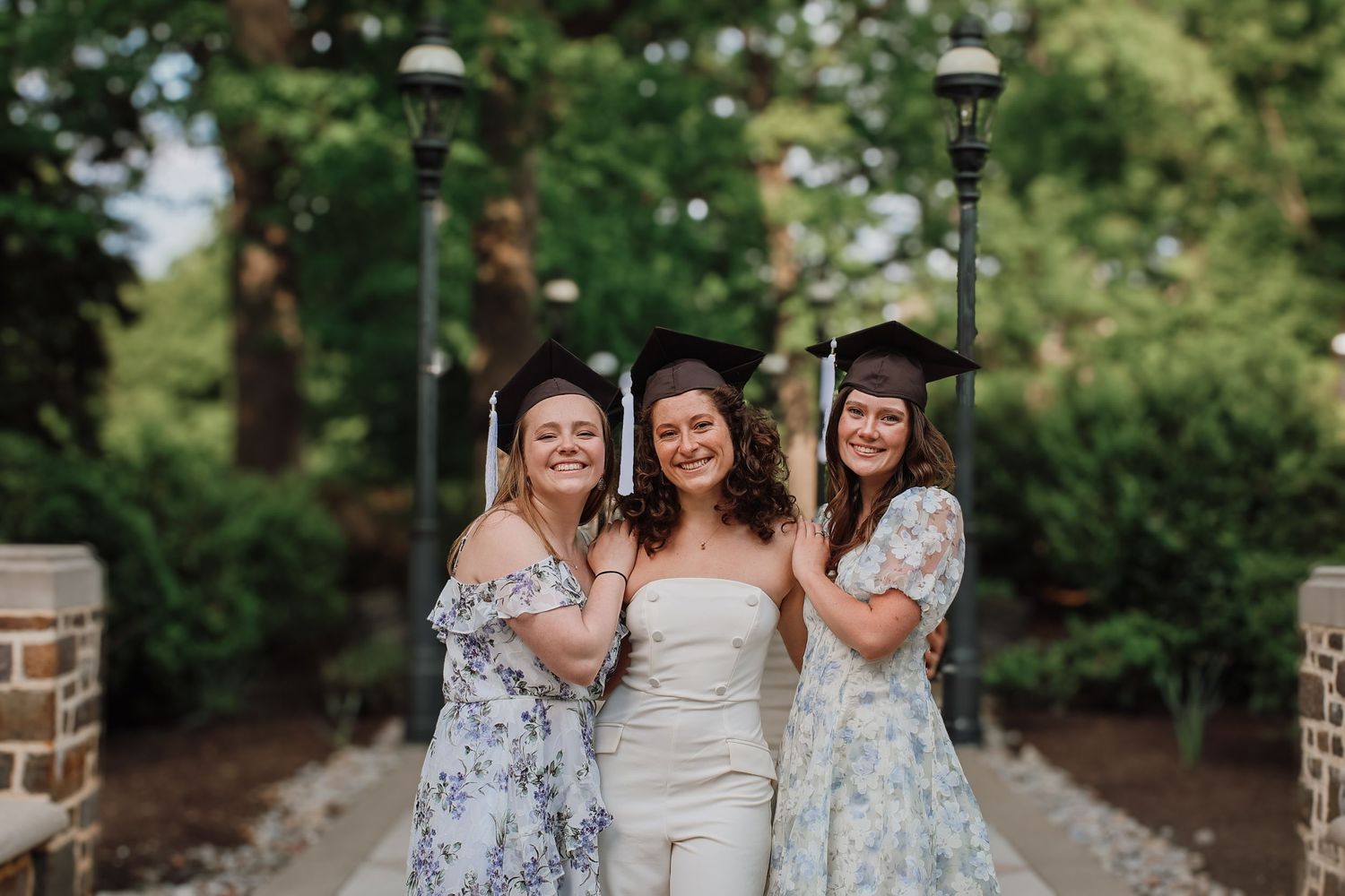 A group of people in formal attire gather together in an outdoor garden setting for a special occasion.