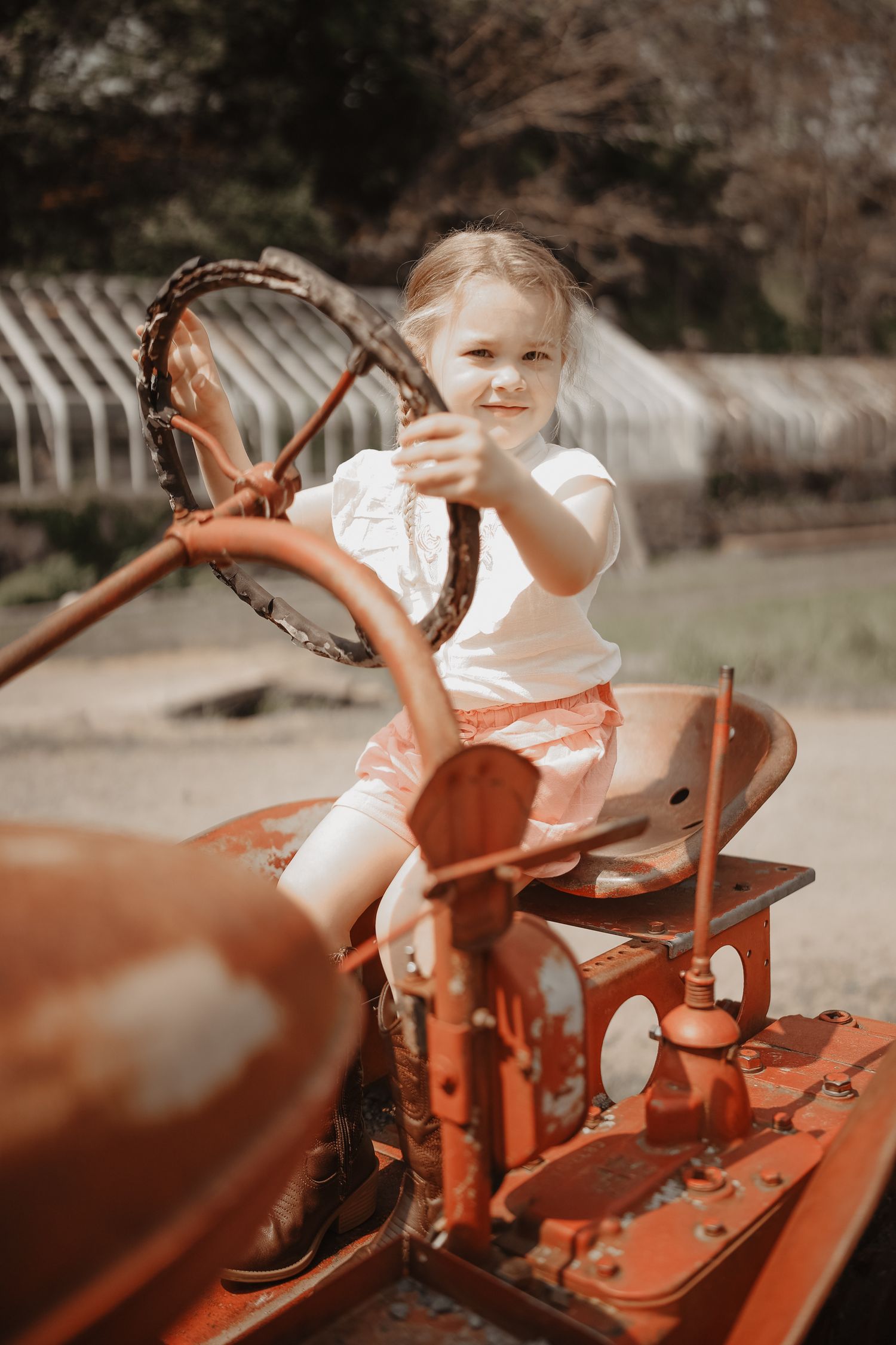 A series of vintage-style photos showing a child playing on an antique red tractor in a sunny outdoor setting.