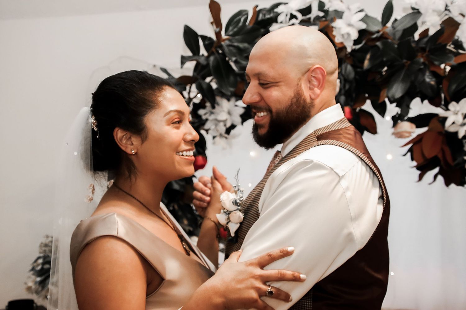 Romantic couple sharing intimate moments during their wedding celebration, surrounded by greenery and natural light.