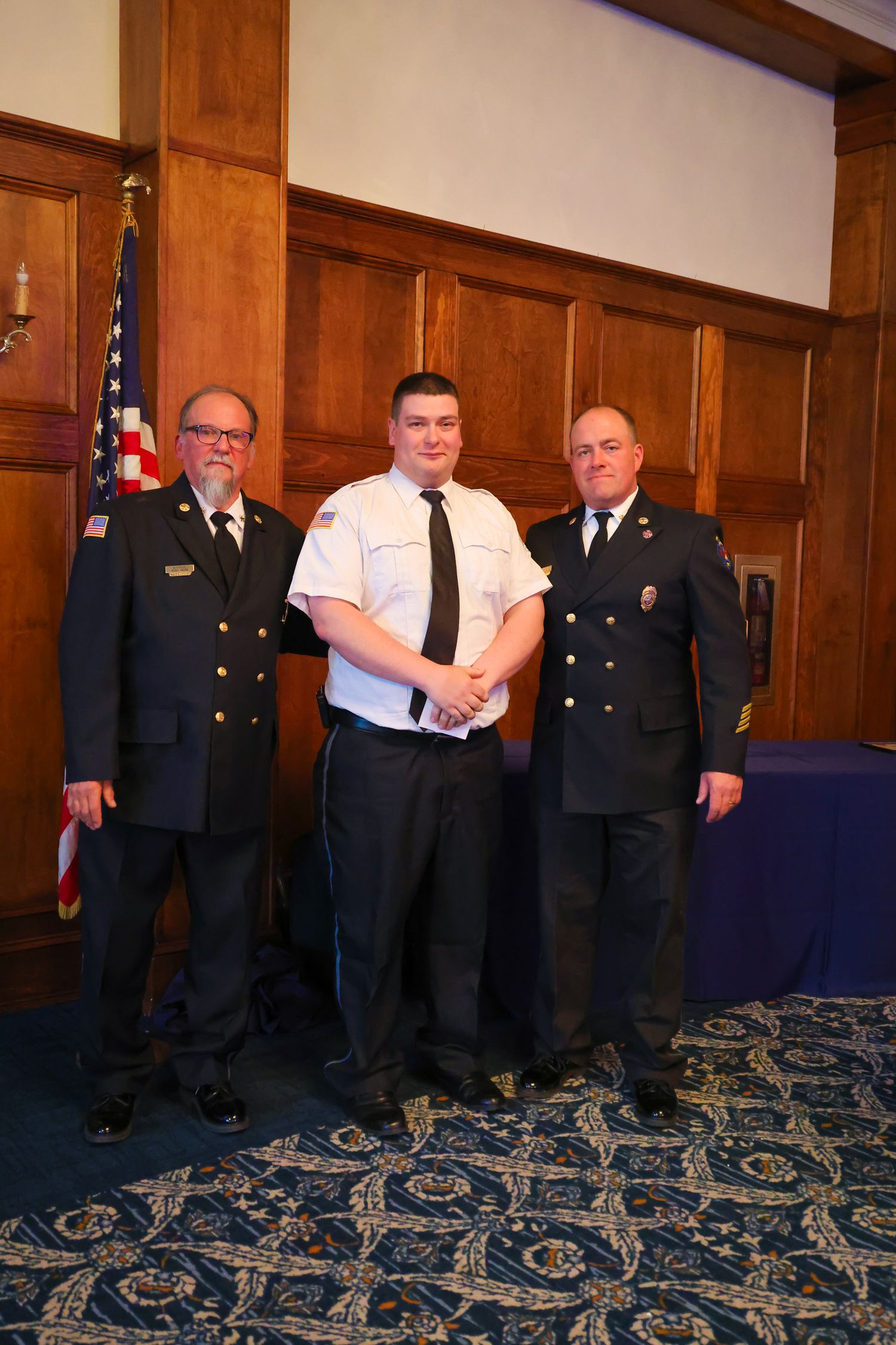 A group of uniformed officials standing in a formal room with ornate carpeting and wood-paneled walls.
