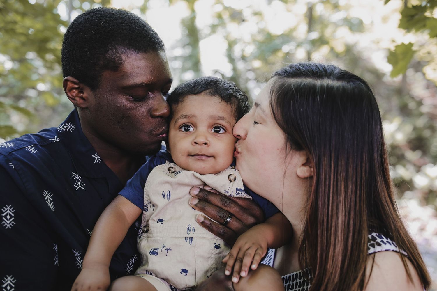 A family shares tender moments of affection and kisses in a series of connected outdoor photos.