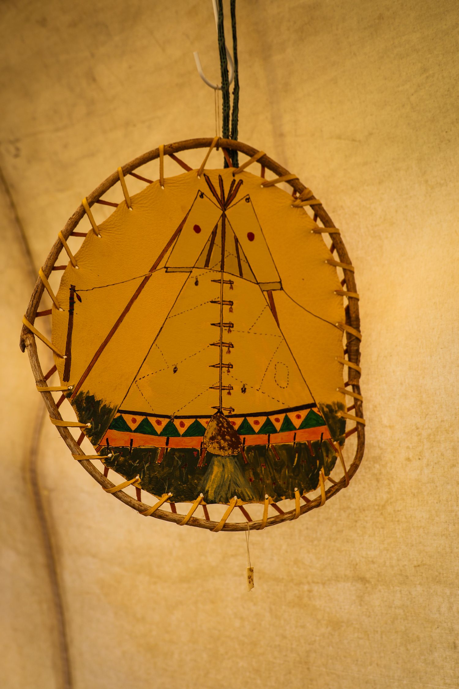 Six circular wall decorations featuring Native American teepee designs on rustic leather or hide material.