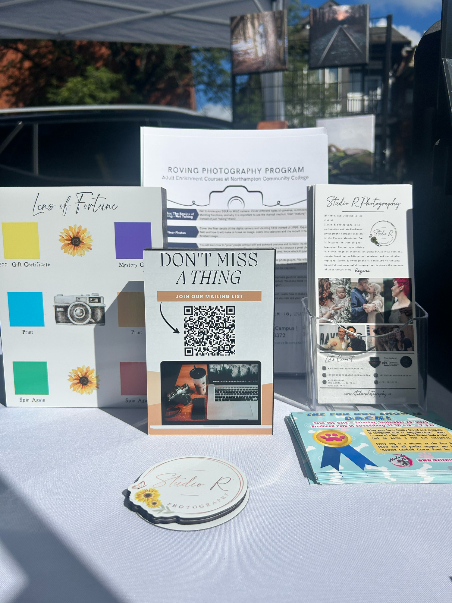 A series of informational flyers and announcements with QR codes displayed on a wall with sunflower decorations.