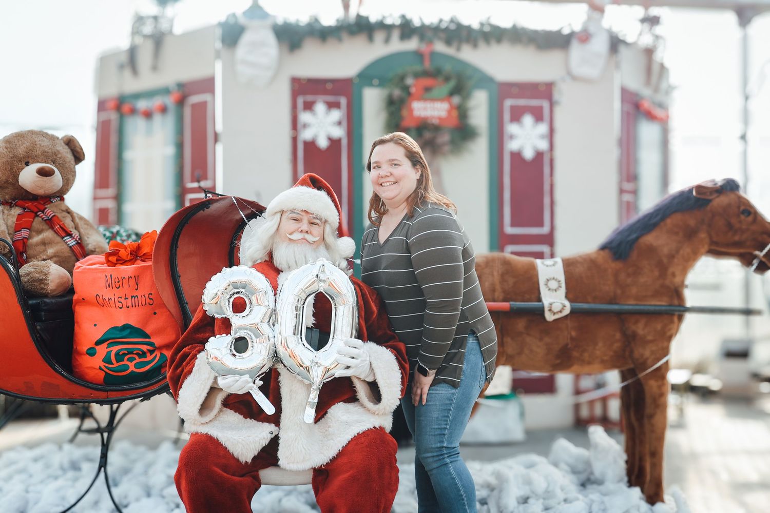 A festive winter scene with a horse-drawn carriage and holiday decorations at a snowy farm.
