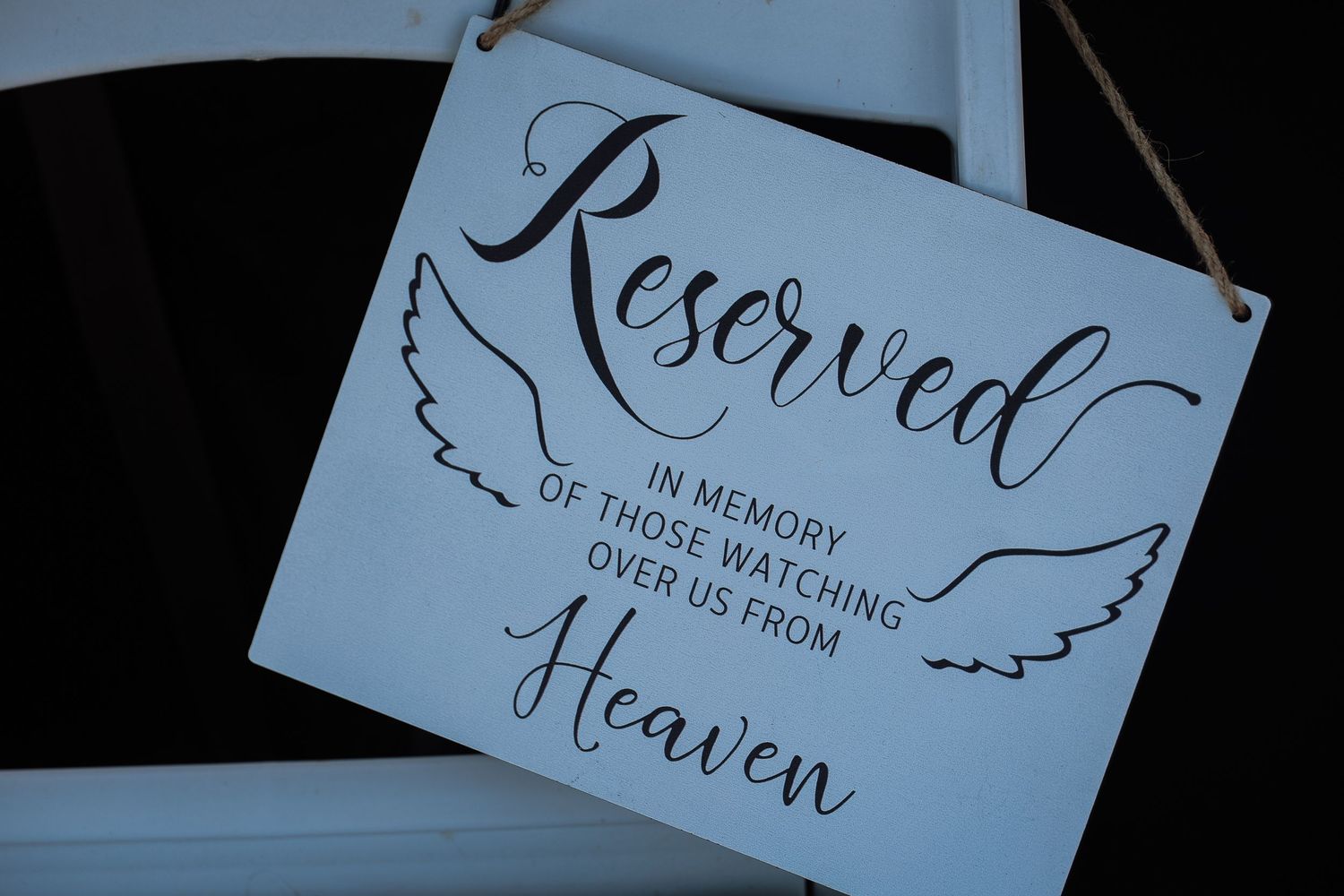 Handwritten calligraphy cards with angel wings designs displayed in a row against a dark background.