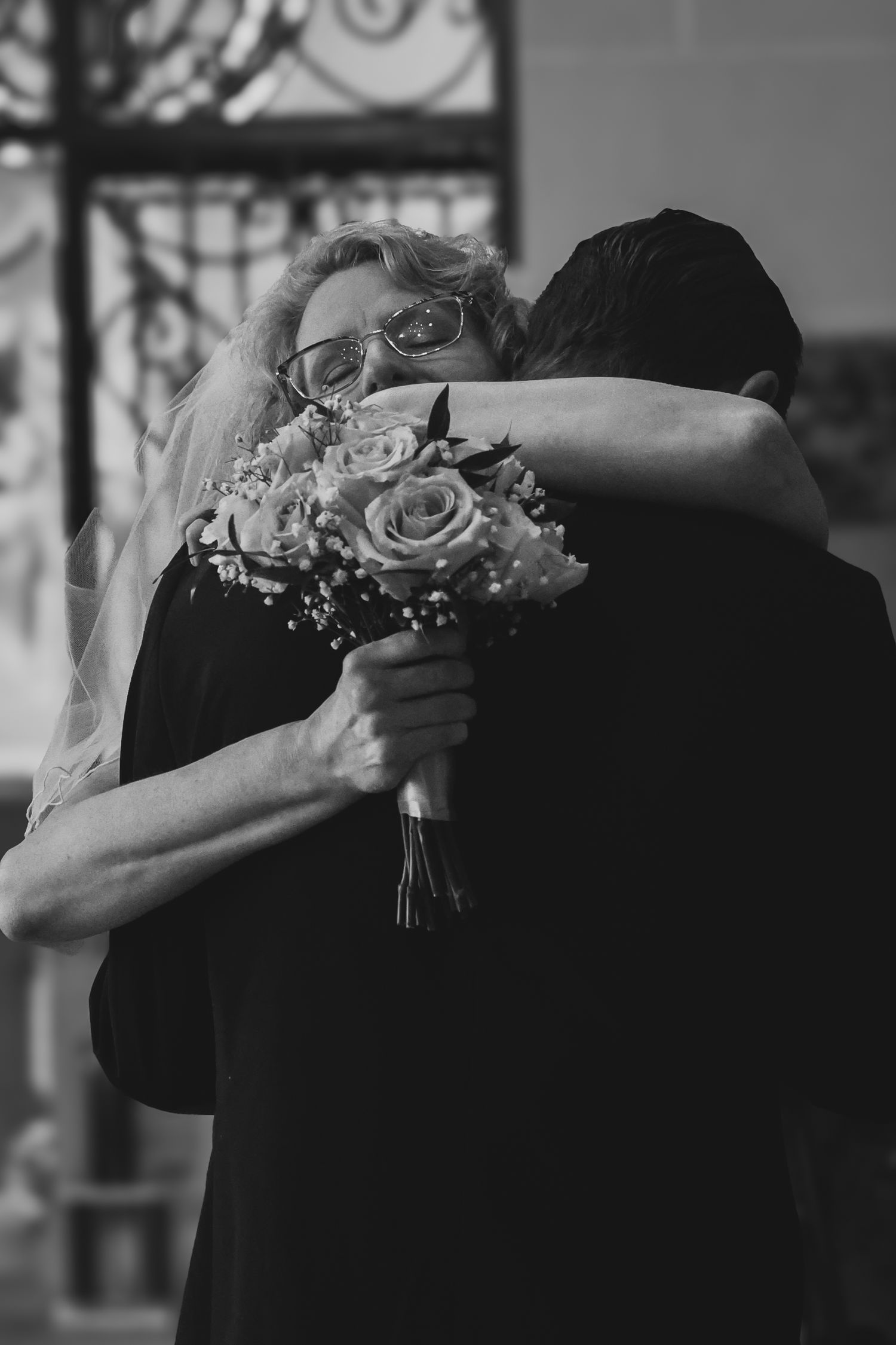 A series of black and white photos showing a couple embracing during a wedding celebration with floral details.