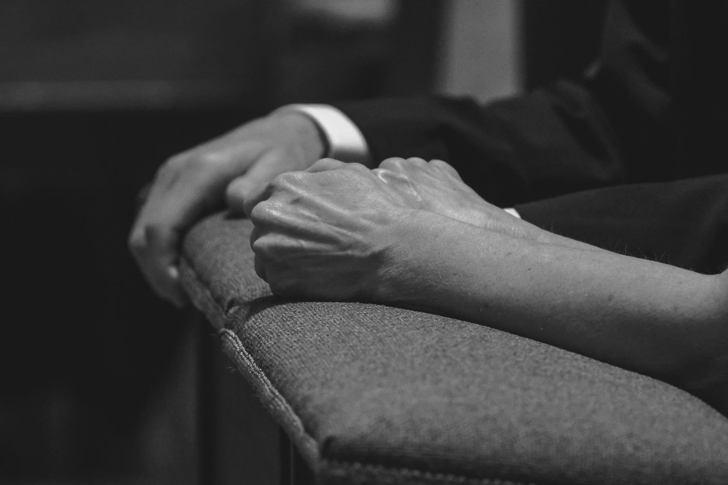 Black and white photo of hands holding a traditional film camera with a vintage lens attachment.