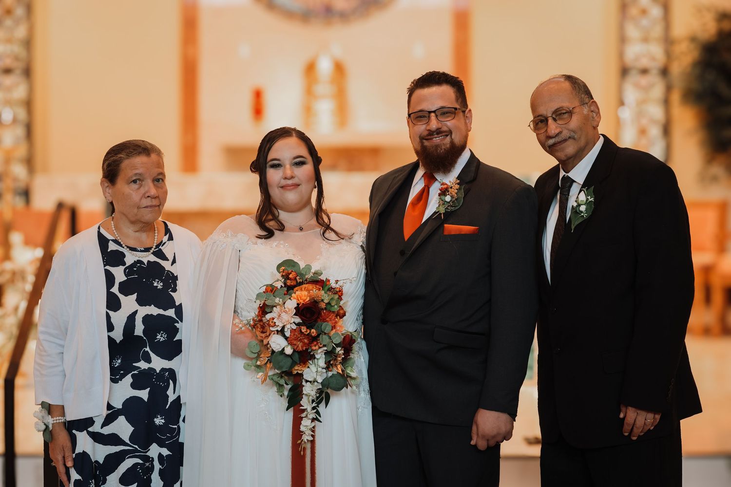 A wedding ceremony takes place in an elegant church with warm lighting and floral decorations.