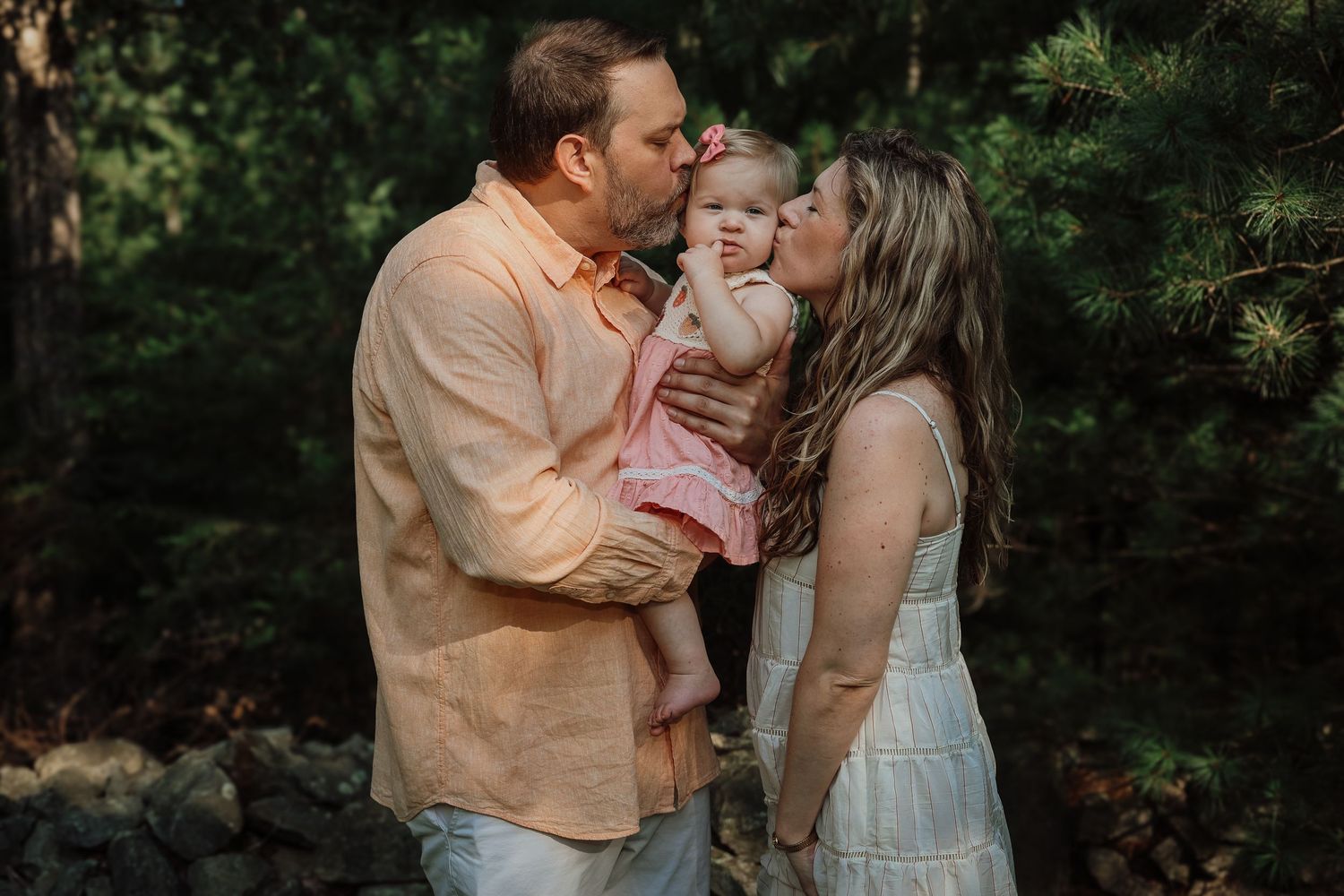 Romantic couple shares intimate moments in a garden setting during a golden hour photoshoot.