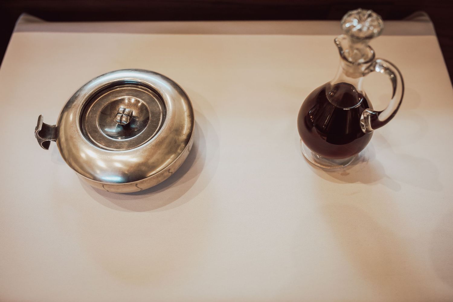 A series of wine glasses and decanters arranged on a white surface in a restaurant setting.