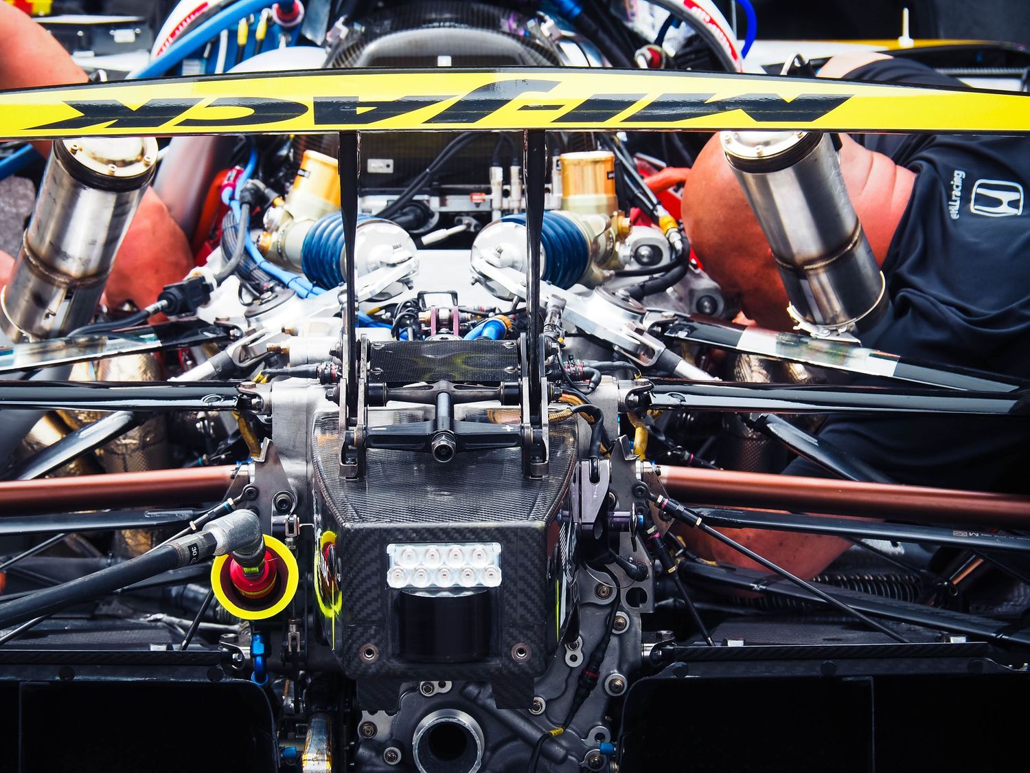 Close-up view of various automotive engine components showing belts, pulleys and mechanical parts under the hood.