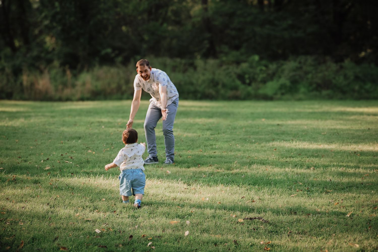 People play together in a grassy field on a bright sunny day.