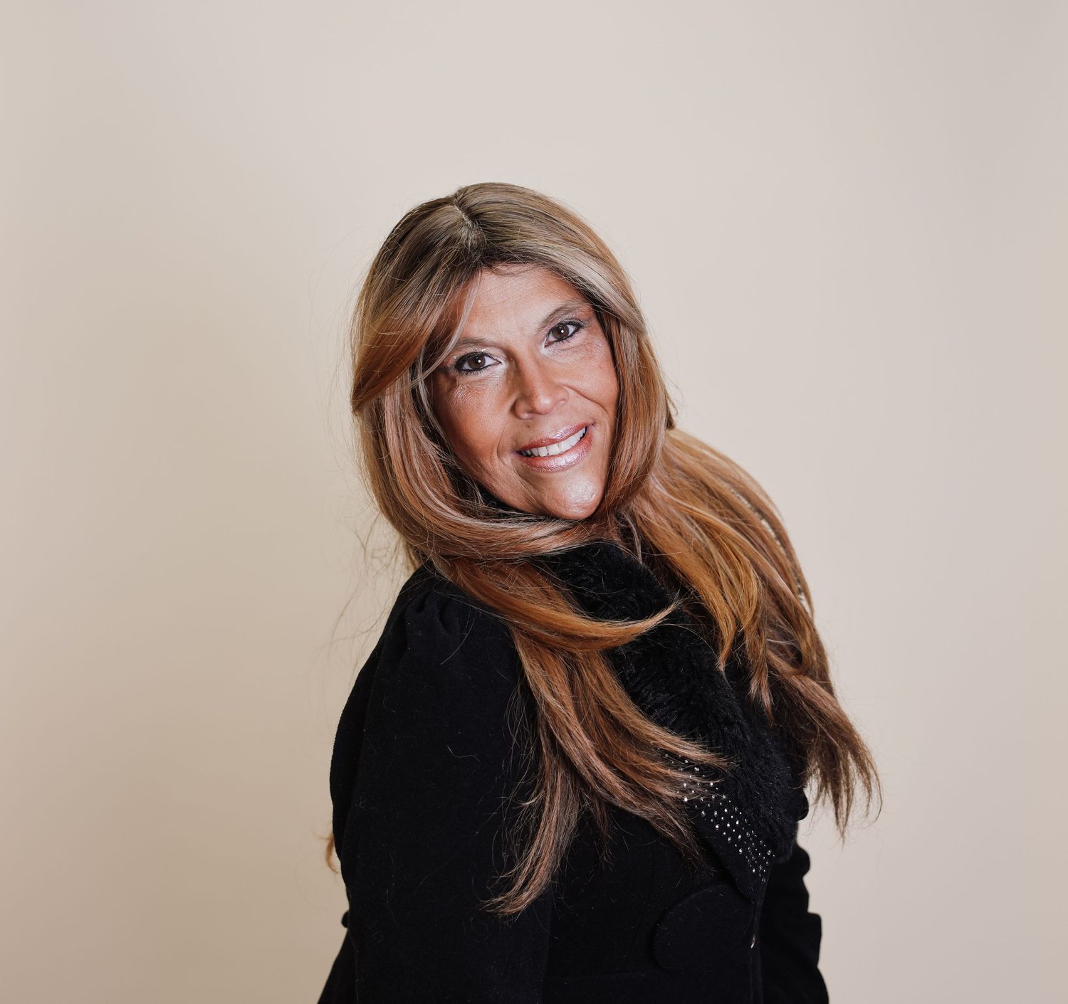 Person with long auburn hair wearing a black outfit poses in a dynamic fashion photoshoot series.
