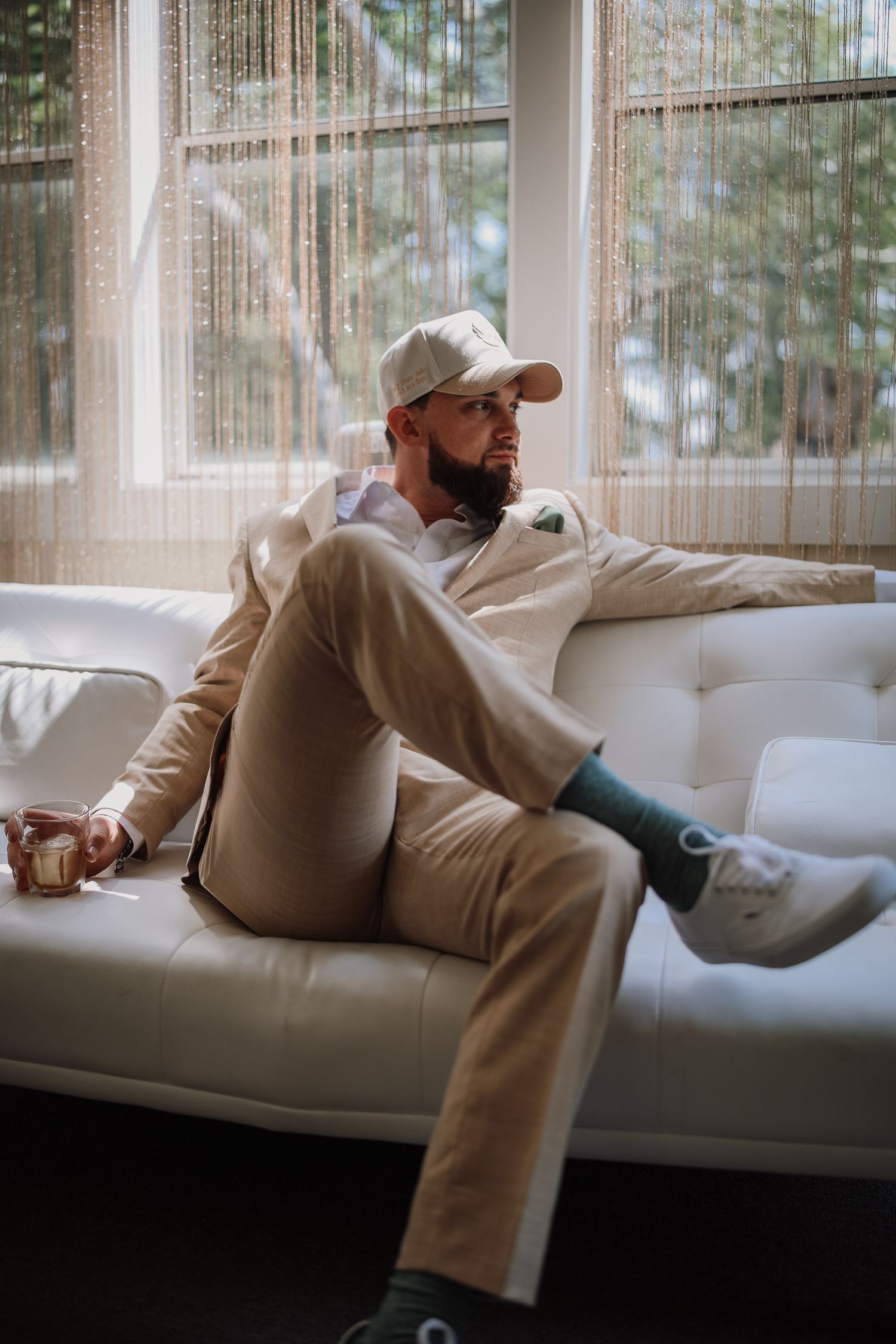 A person in beige clothing reclines on a white couch near sunlit windows in a series of connected photos.