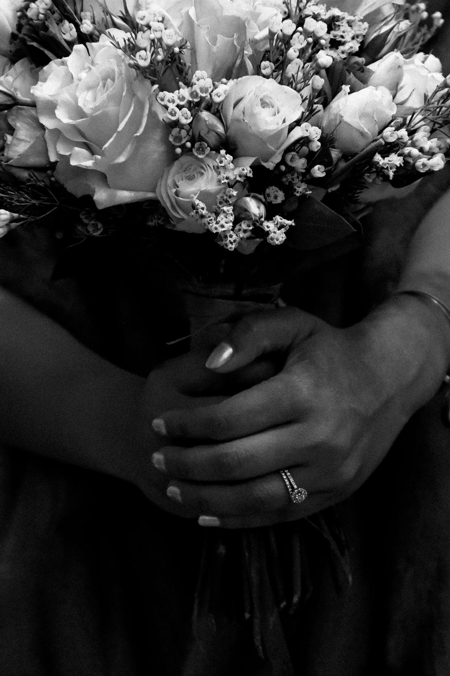 A black and white photo series showing hands holding a bouquet of white roses and baby's breath flowers.