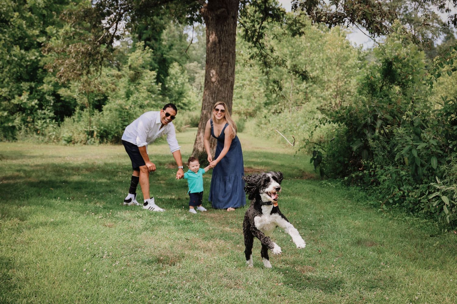 People enjoying a sunny day in a lush green park setting during an outdoor photoshoot session.