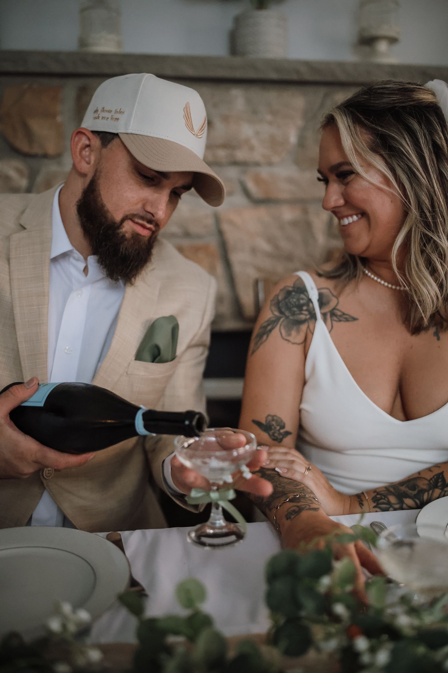 Couple sharing intimate moments while drinking from glasses at a rustic stone counter.