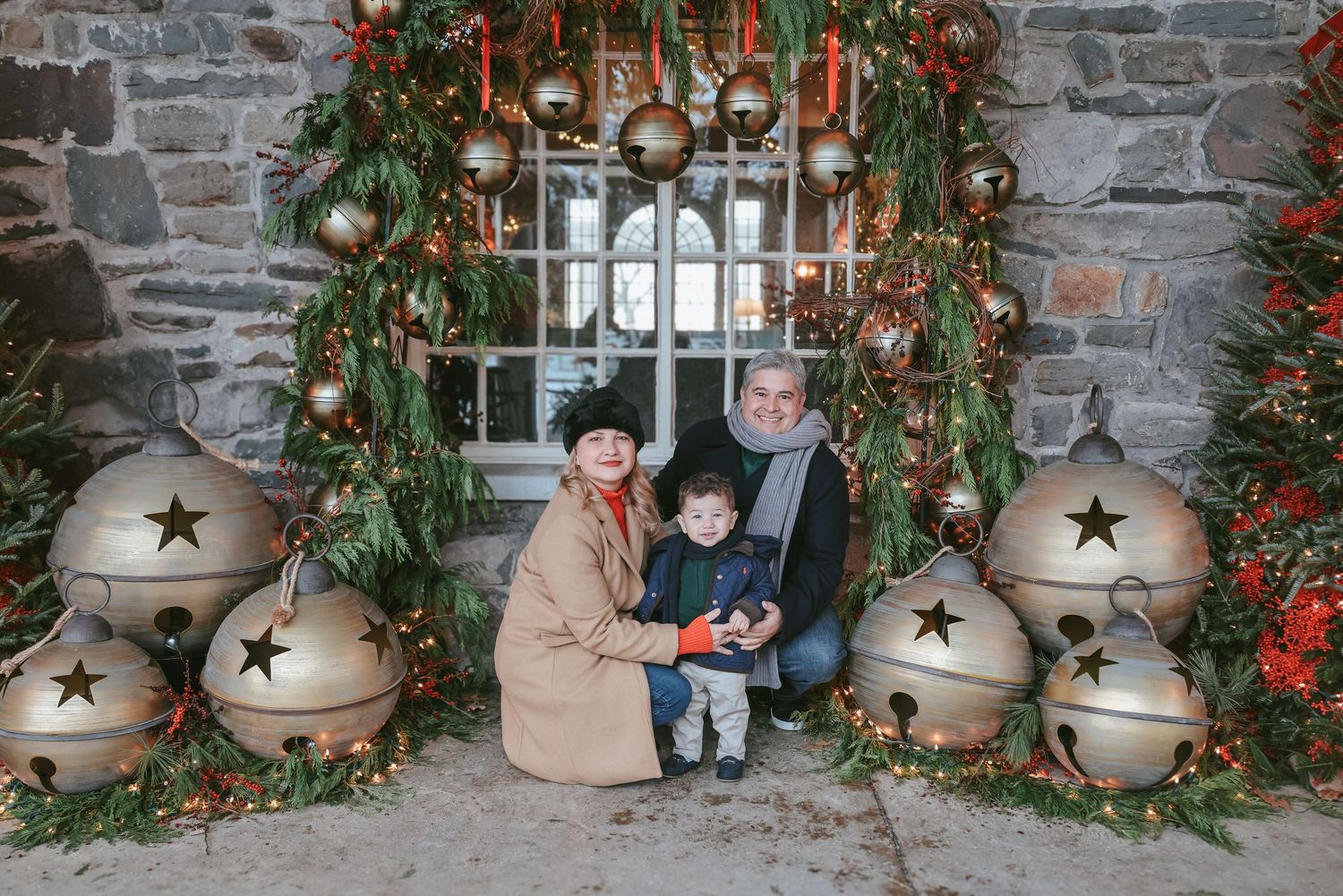A series of five holiday photos featuring rustic stone walls, decorative bells, greenery, and festive Christmas decor.
