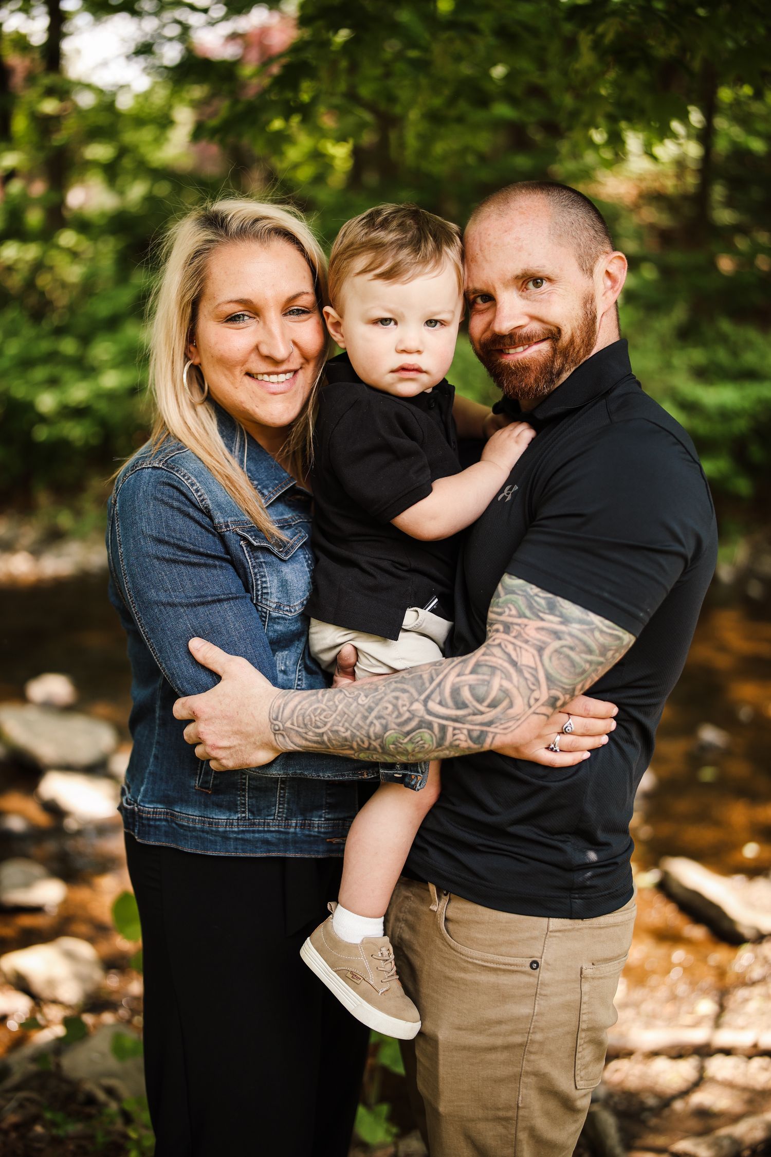 Family enjoying a candid moment together outdoors in nature with trees and rocks in the background.