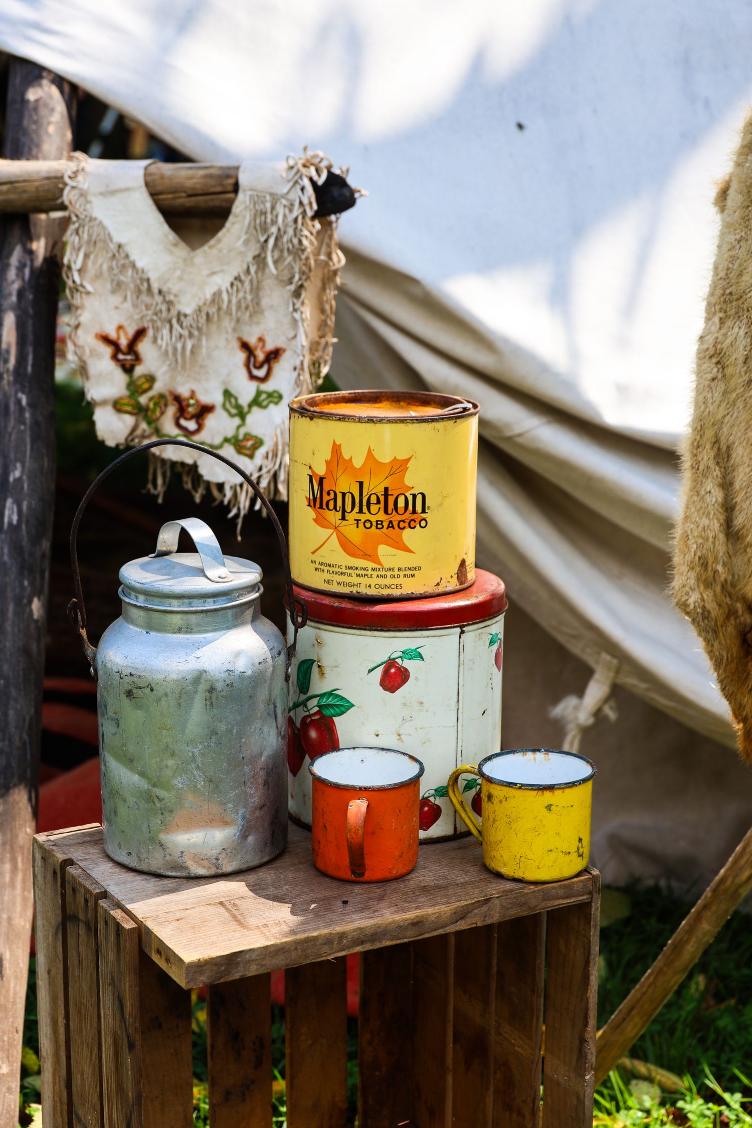 Vintage metal teapots and canisters arranged on rustic wooden shelves create a charming farmhouse display.