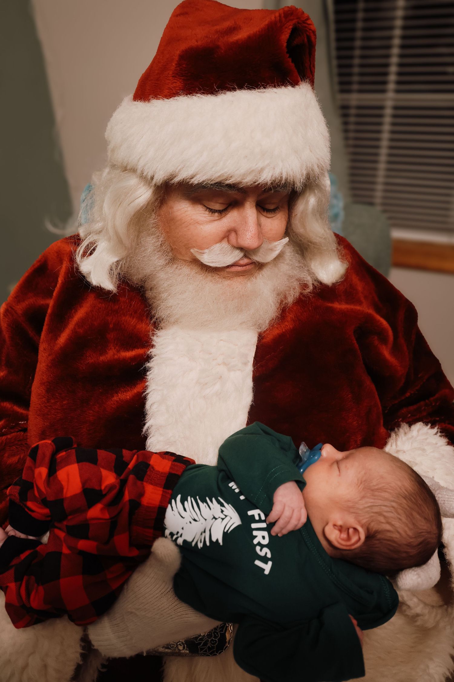 A series of photos showing Santa Claus holding and interacting with a small baby wearing a dark green outfit.